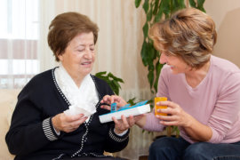 caregiver giving a medicine to an old woman