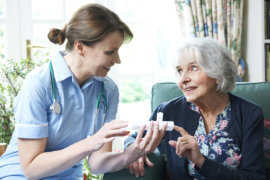 nurse assisting an old woman